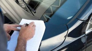 guy writing on paper in front of car |Porsche 911 Pre Purchase Inspection | Porsche 911 | Porsche Madness